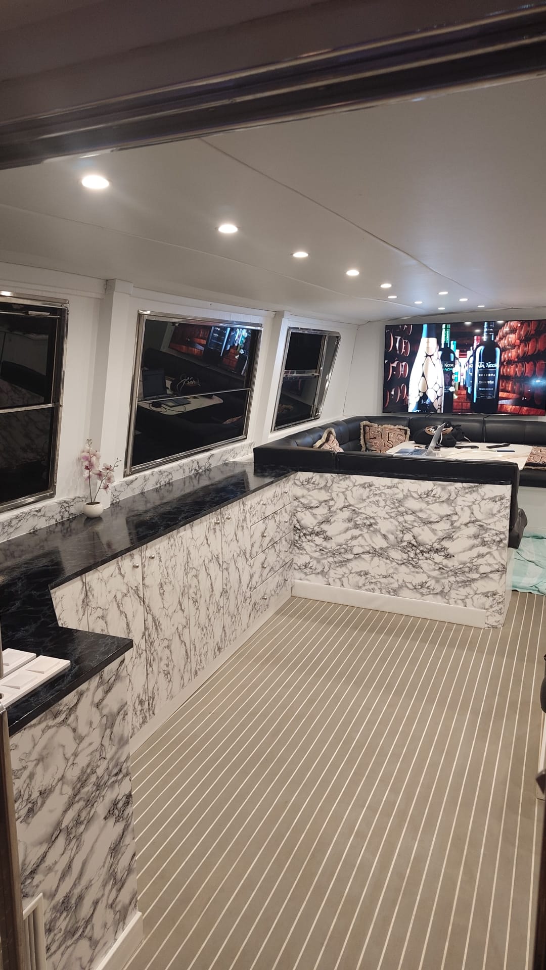 Salón reformado: barra de mármol, sofá en U y gran pantalla